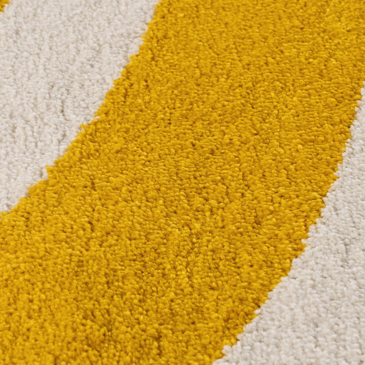 Close-up of a yellow and beige geometric patterned rug.