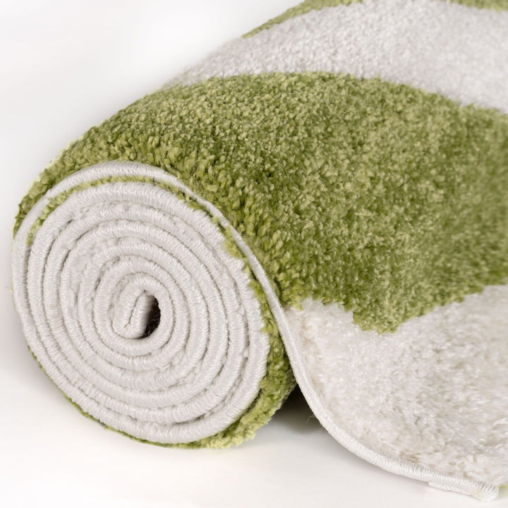 Green and white folded rug on a white background