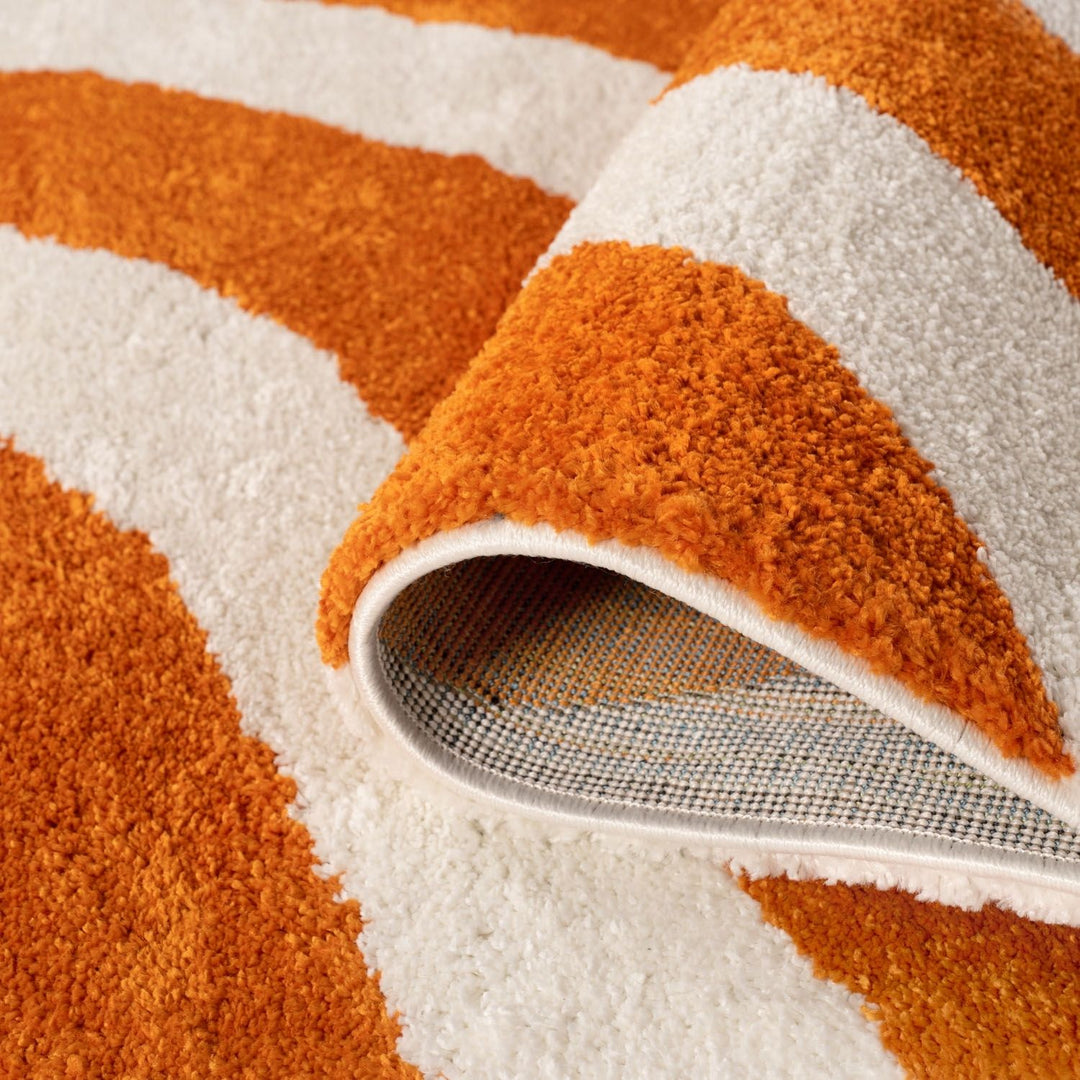 Close-up of an orange and white patterned rug with a textured border.