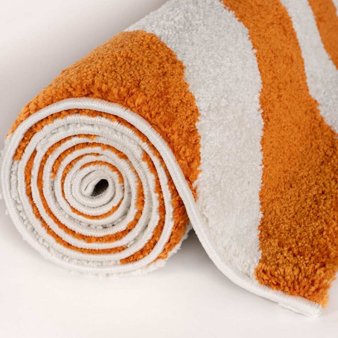 Rolled-up orange and white rug on a light gray background