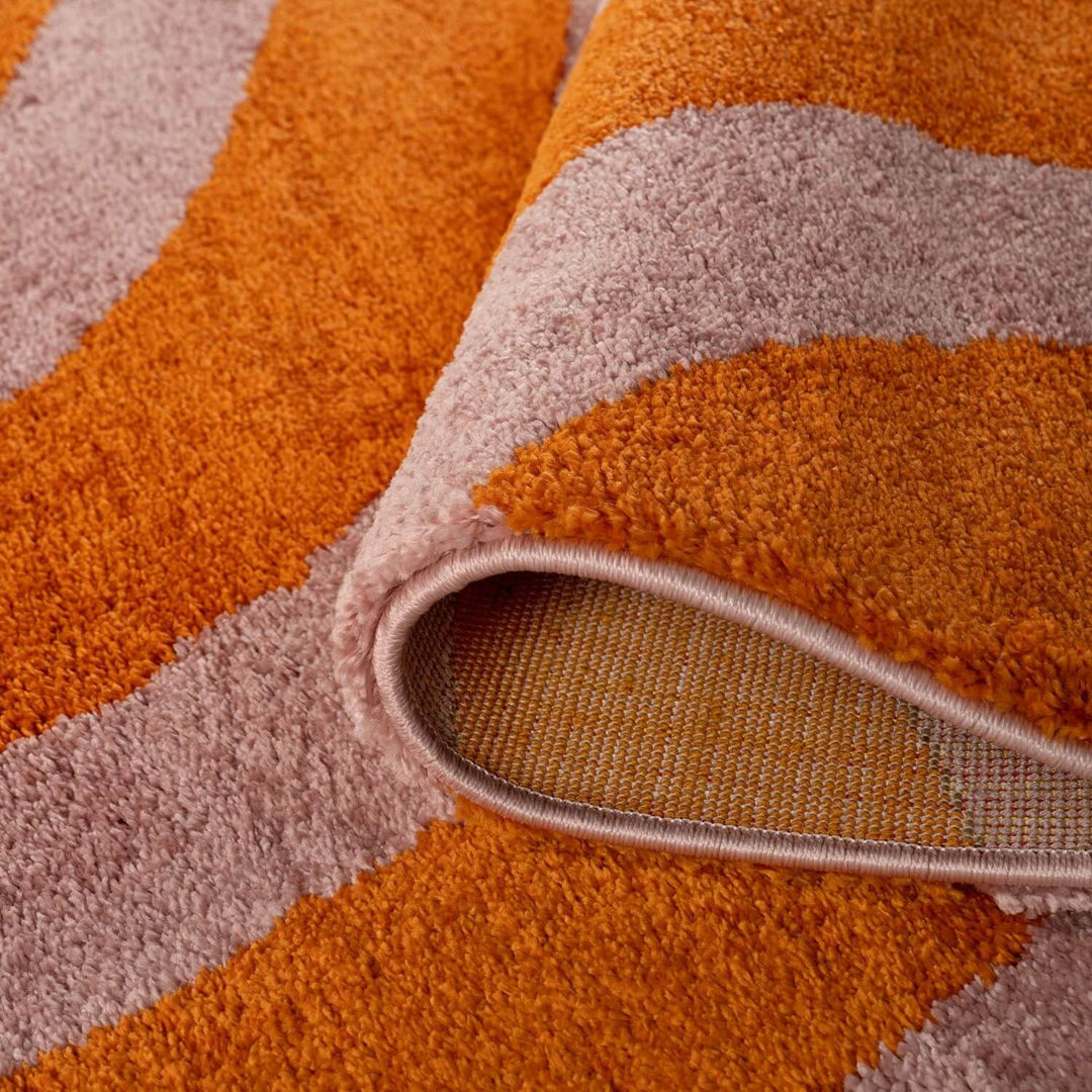 Close-up of a textured orange and beige rug with a visible pile.