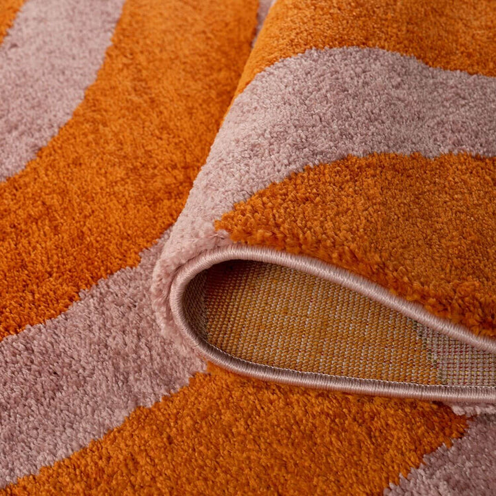 Close-up of a textured orange and beige rug with a visible pile.