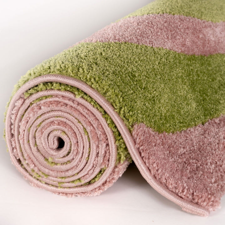 Rolled-up pink and green towel on a white background