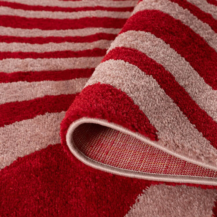 Close-up of a red and beige striped rug with a textured surface.