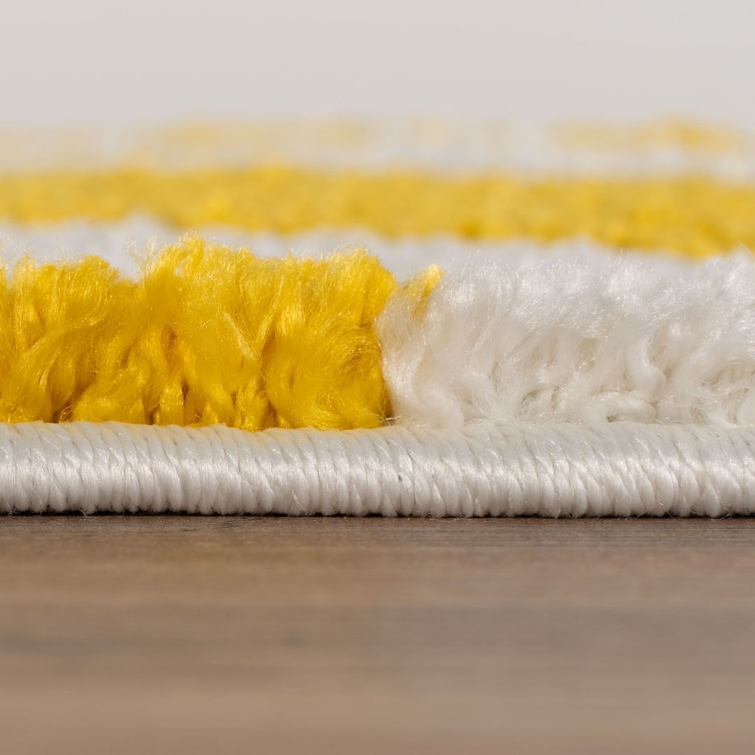 Close-up of a yellow and white scrub brush on a wooden surface.