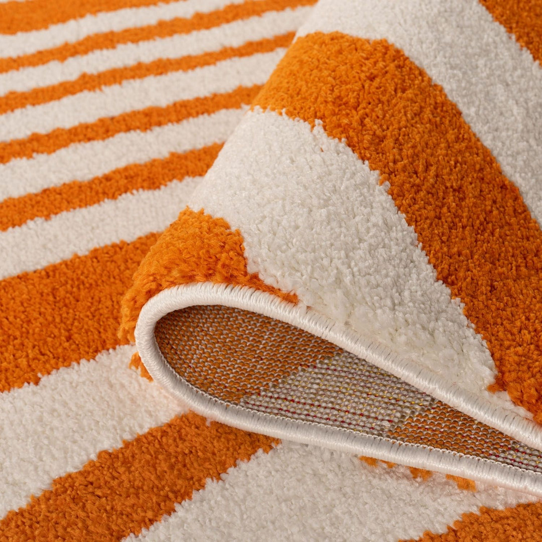 Close-up of an orange and white striped rug with a textured surface.