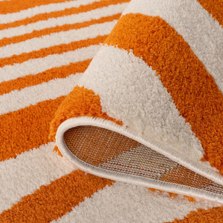 Close-up of an orange and white striped rug with a textured surface.