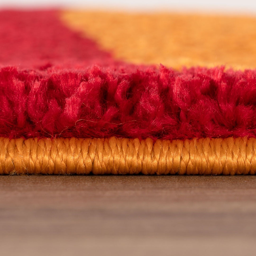 Close-up of red and gold textured fabric on a wooden surface
