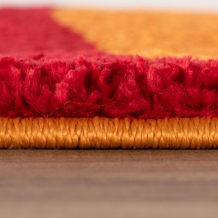 Close-up of red and gold textured fabric on a wooden surface