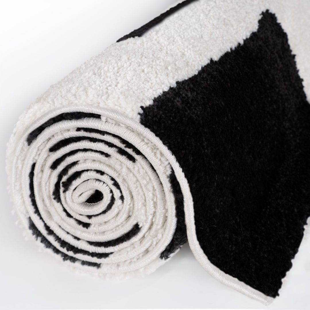 Roll of black and white textured fabric on a white background