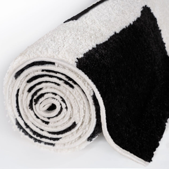 Roll of black and white textured fabric on a white background