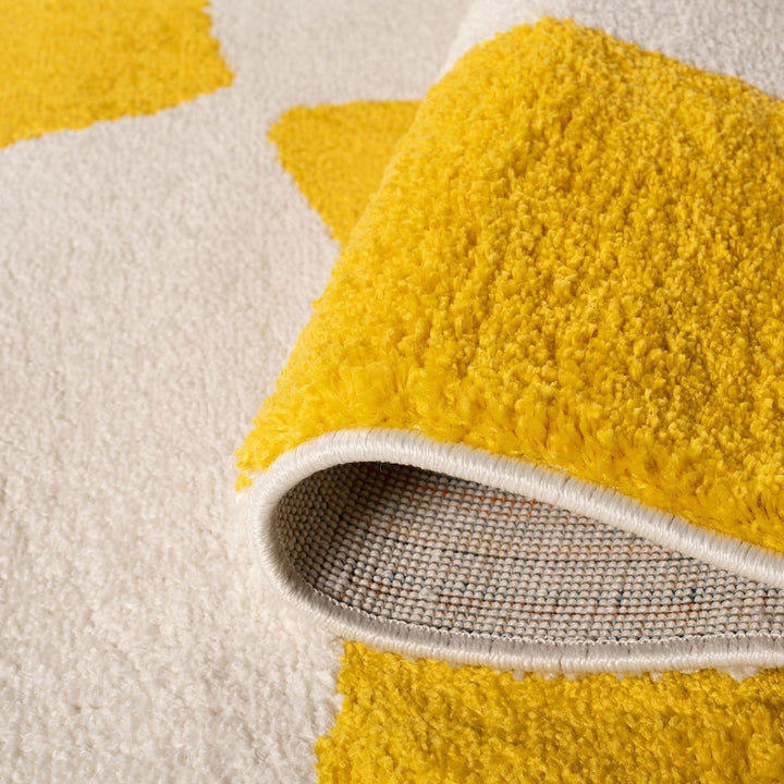 Close-up of a yellow textured rug with a white border on a beige background