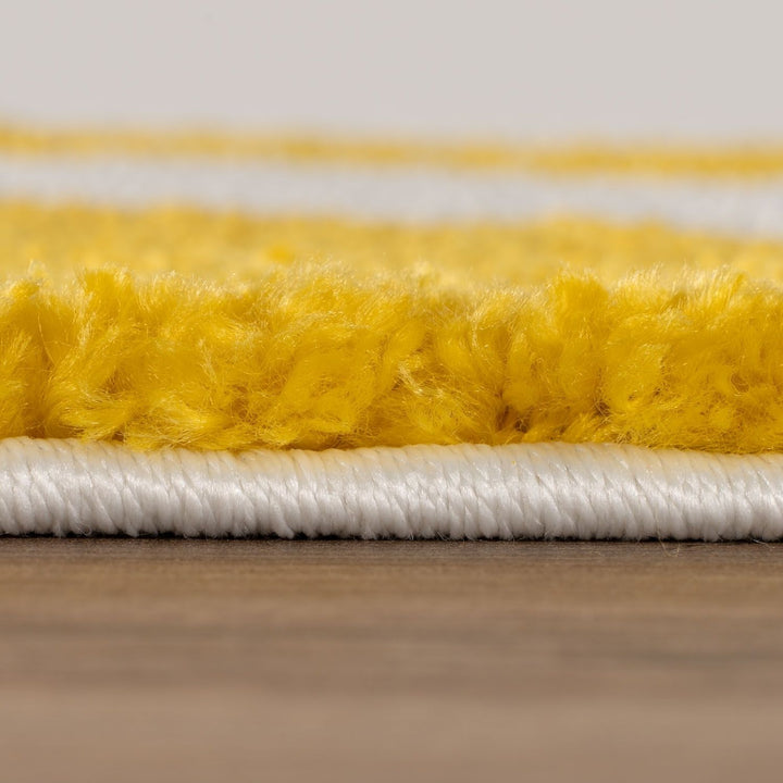 Close-up of yellow and white textured carpet on a wooden floor.