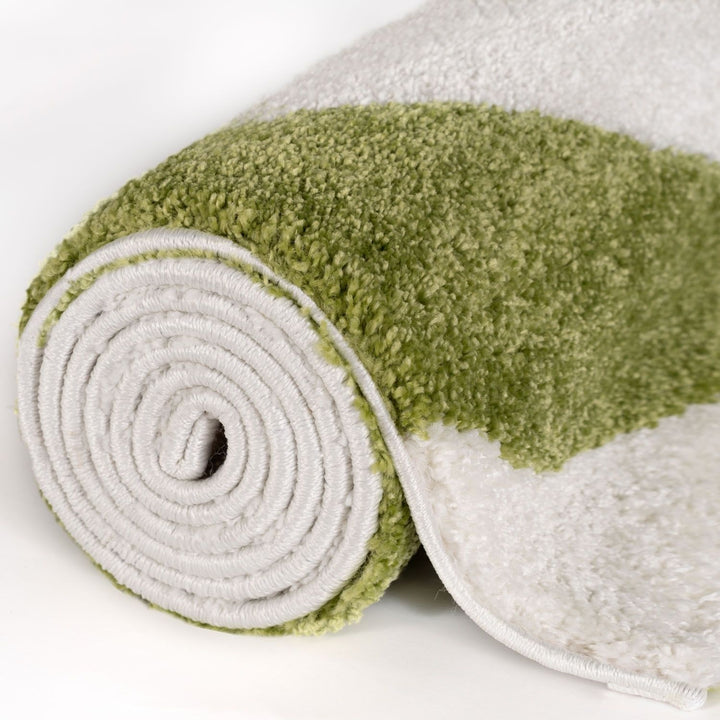 Green and white textured rug rolled up on a light background
