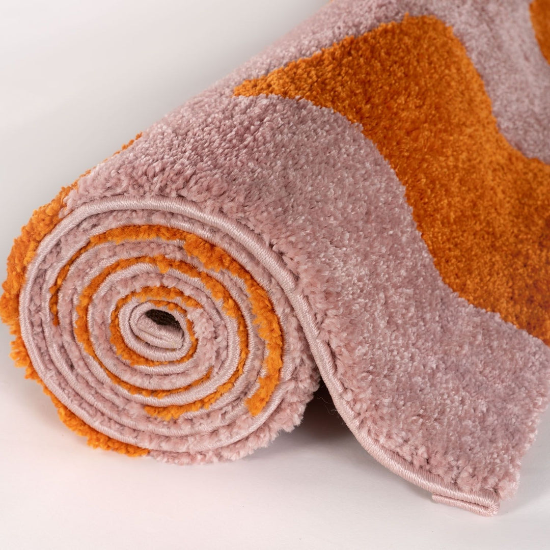 Rolled-up pink and orange towel on a light gray background