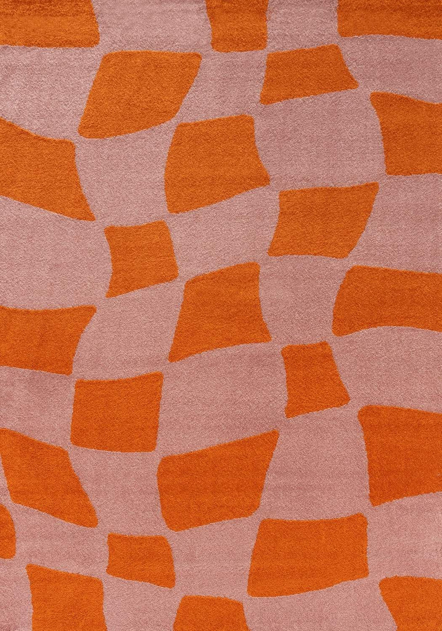 Patterned fabric with orange geometric shapes on a pink background