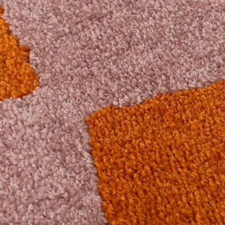 Close-up of a textured orange and pink carpet