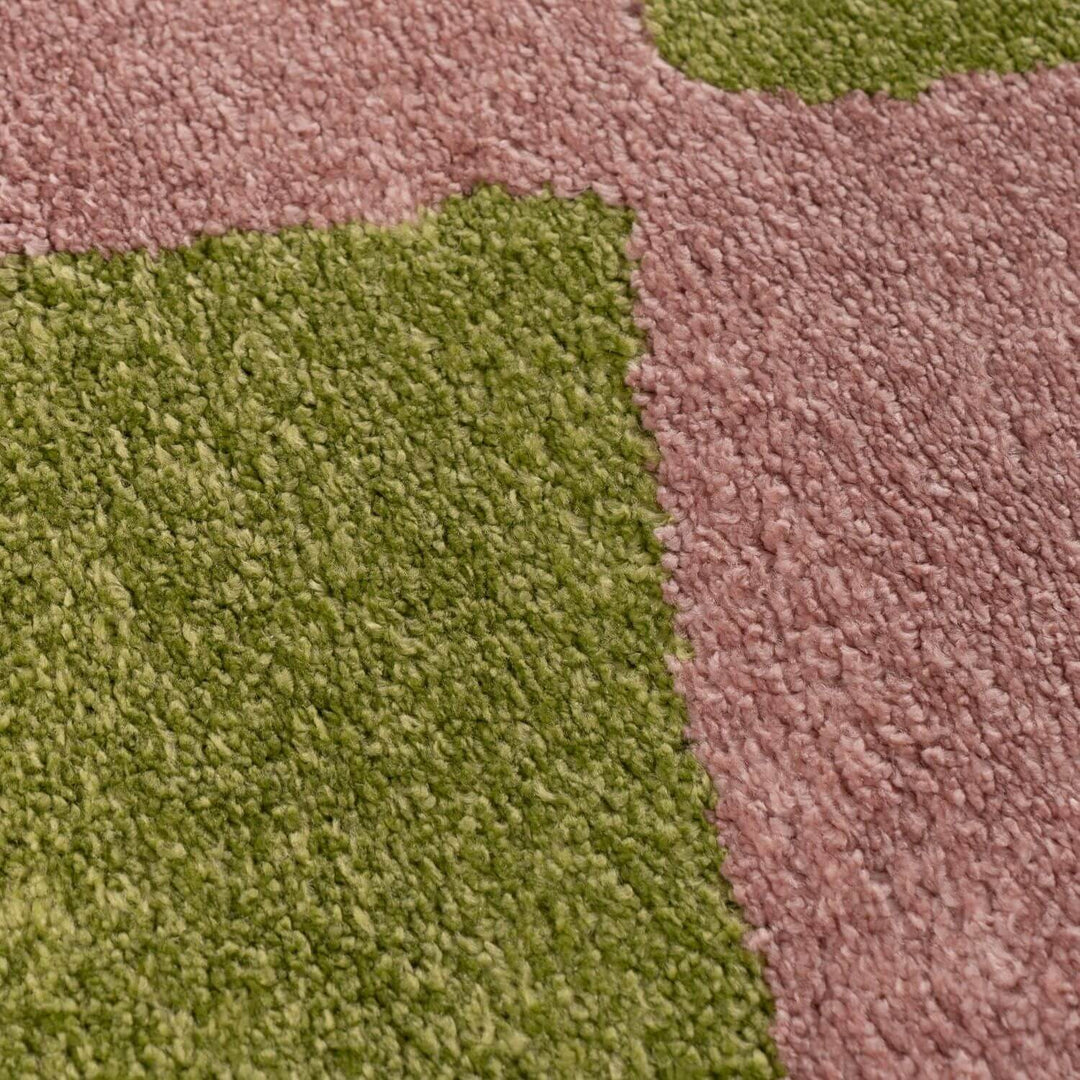 Close-up of a multicolored textured fabric with green and pink sections.