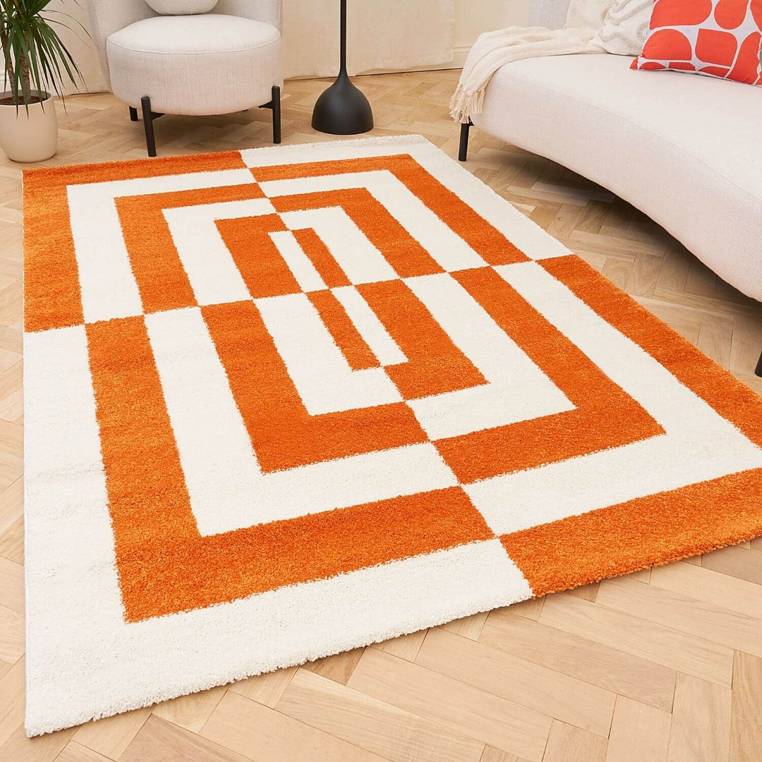 Orange and white geometric patterned rug on a wooden floor