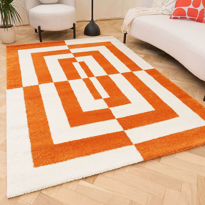 Orange and white geometric patterned rug on a wooden floor