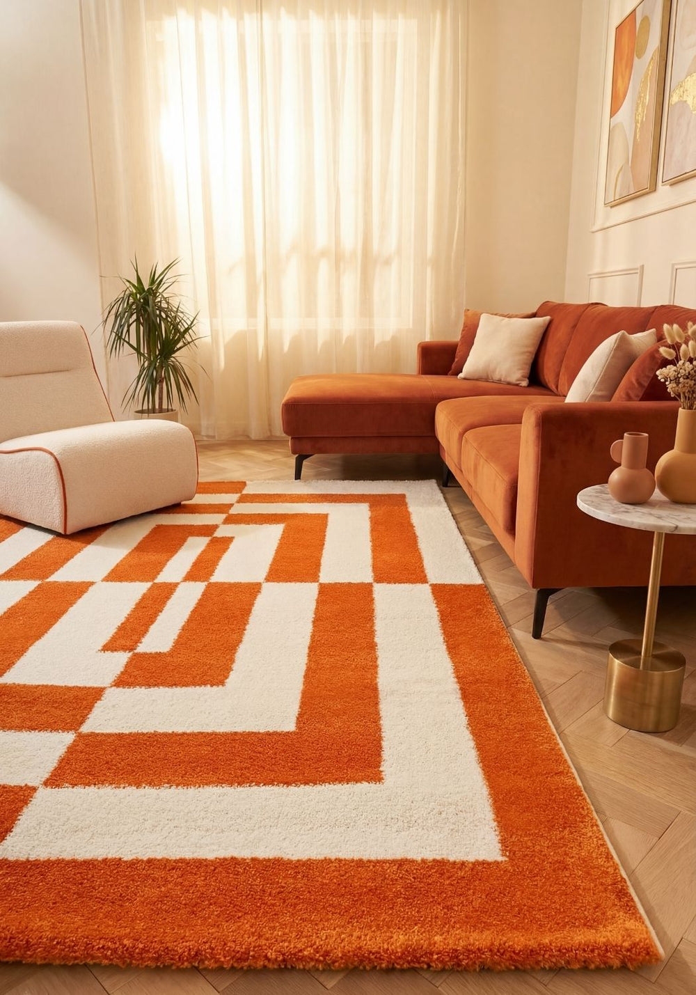 Living room with an orange and white geometric rug, red sofa, and beige walls.