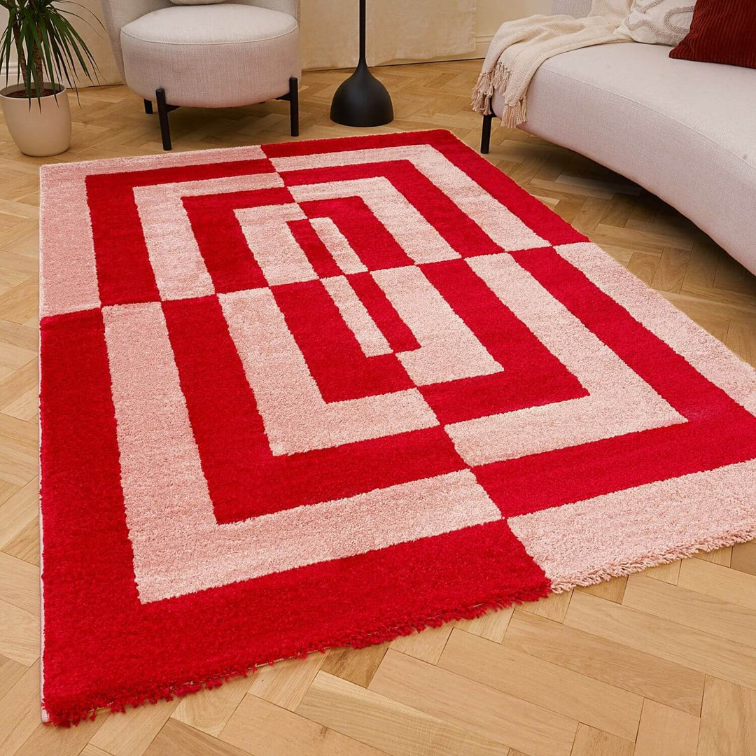 Red and white geometric patterned rug on a wooden floor