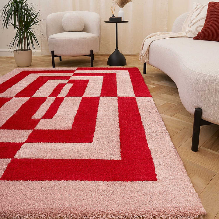 Red and beige geometric patterned rug in a living room setting with furniture and decor.