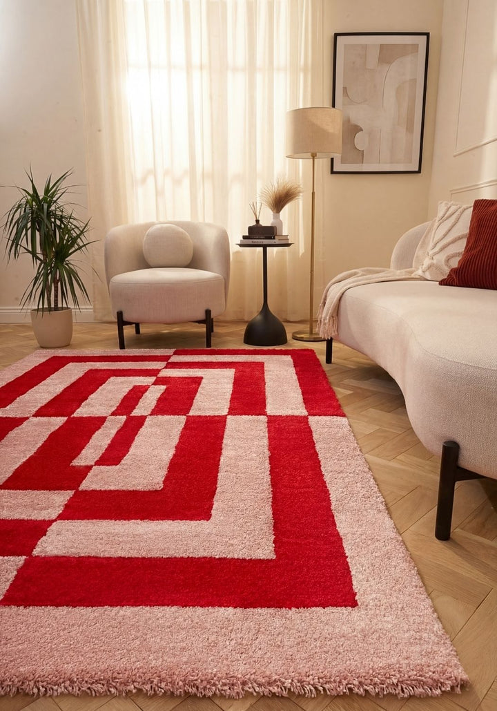 Living room with a red and white patterned rug, beige armchair, and sofa.
