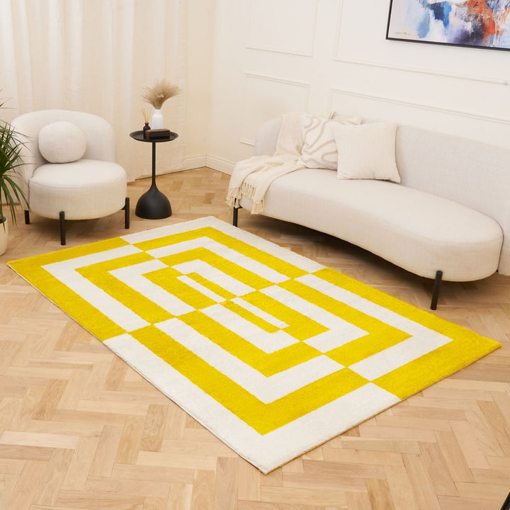 Yellow and white geometric rug in a living room with a sofa and chair.