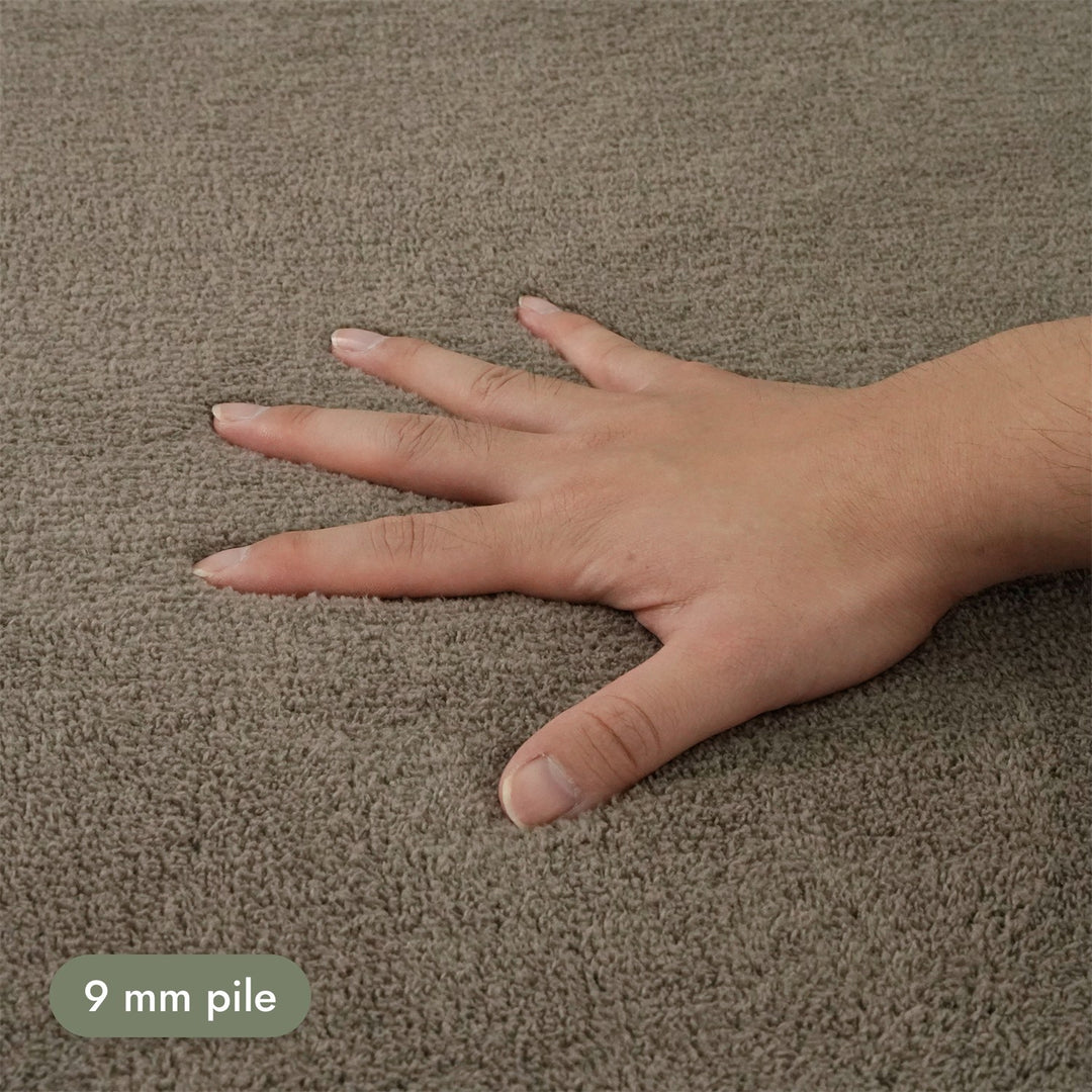 Washmellow light brown washable rug, close-up of the soft 9mm pile under a hand | The Rugs