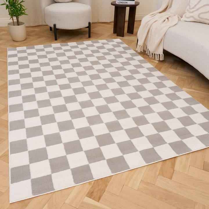 Checkered rug with gray and white squares on a wooden floor