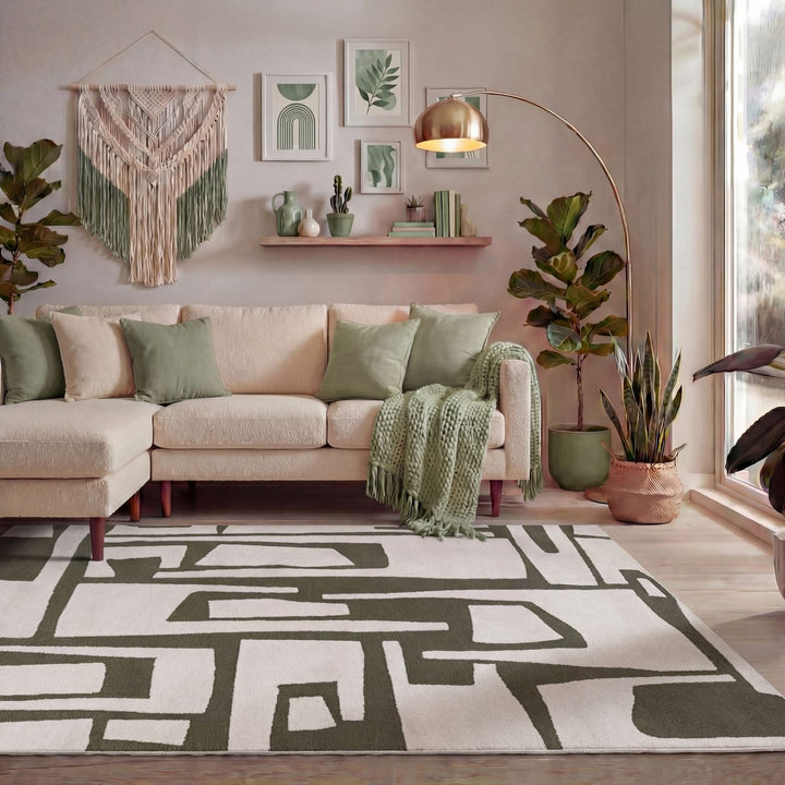 Modern living room with a beige sectional sofa, decorative pillows, and a patterned rug.