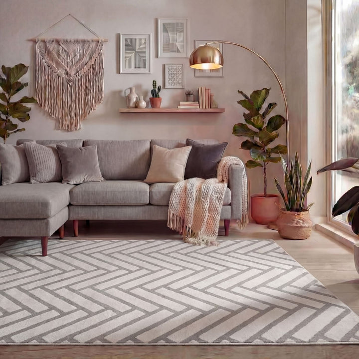 Living room with a gray sectional sofa, patterned rug, and decorative elements.