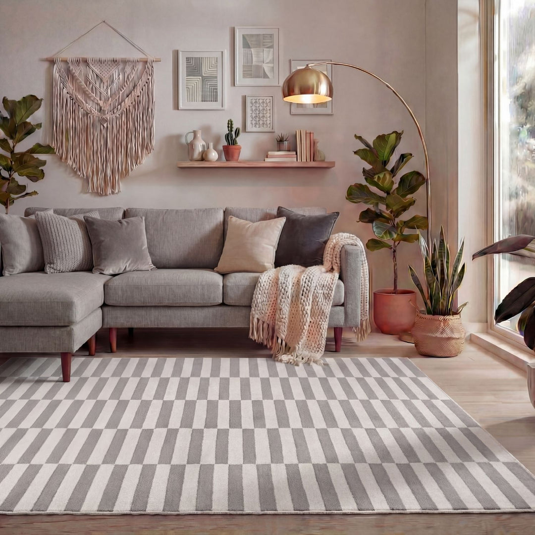 Living room with a gray sectional sofa, striped rug, and decorative elements.