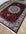 Decorative red and silver area rug on a wooden floor