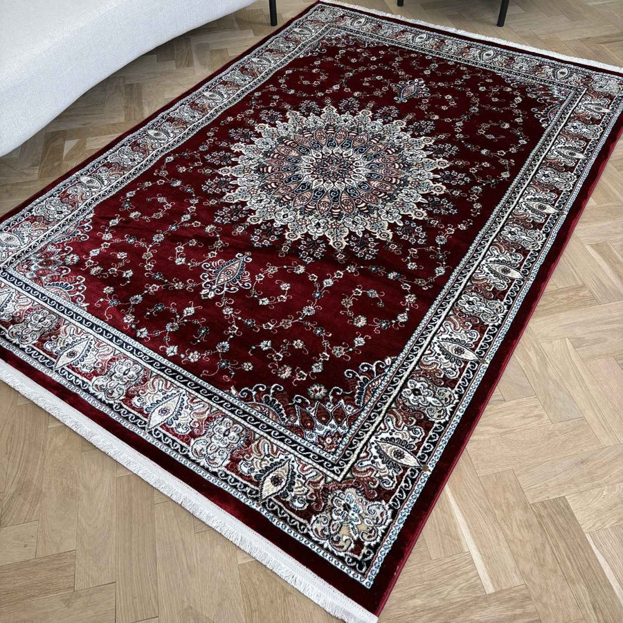 Decorative red and silver area rug on a wooden floor