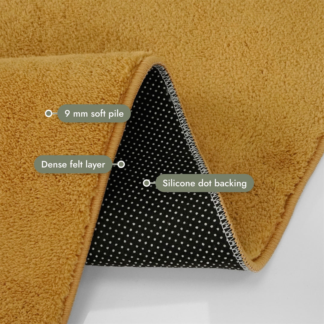 Washmellow ochre washable rug, folded corner showing the pile, felt layer and backing | The Rugs