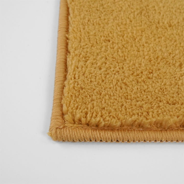 Washmellow ochre washable rug, close-up of the corner and bound edge | The Rugs