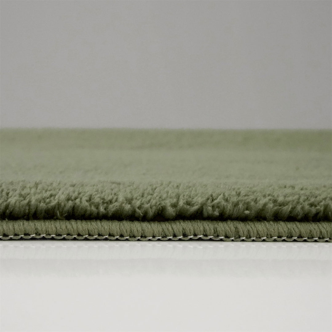 Washmellow olive green washable rug, side view of the low pile and edge at floor level | The Rugs
