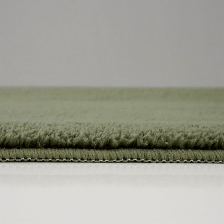 Washmellow olive green washable rug, side view of the low pile and edge at floor level | The Rugs