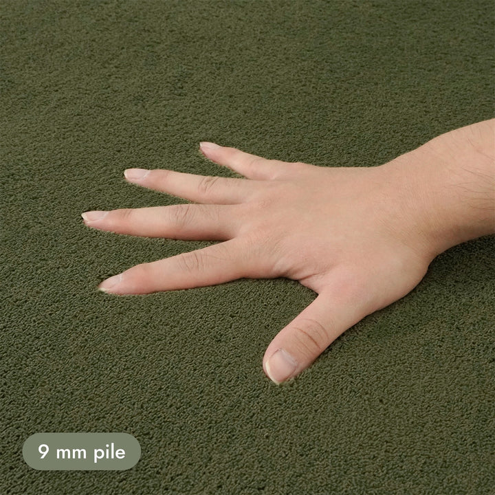 Washmellow olive green washable rug, close-up of the soft 9mm pile under a hand | The Rugs