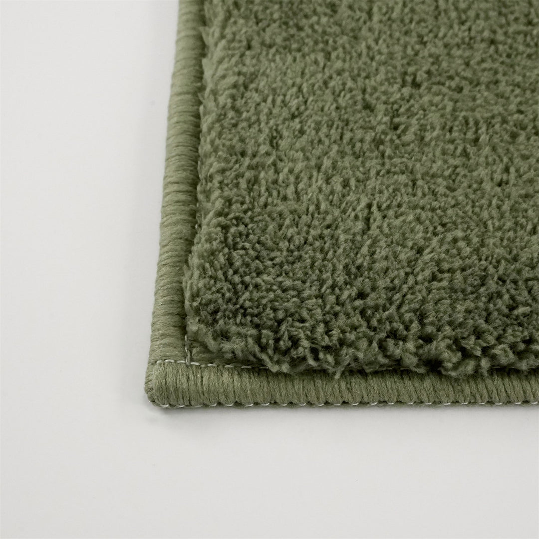 Washmellow olive green washable rug, close-up of the corner and bound edge | The Rugs