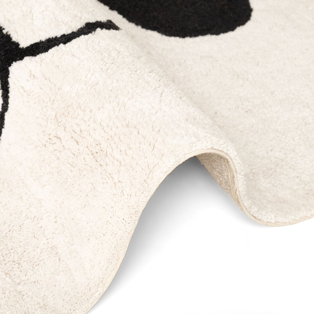 Close-up of a textured white rug with black abstract design