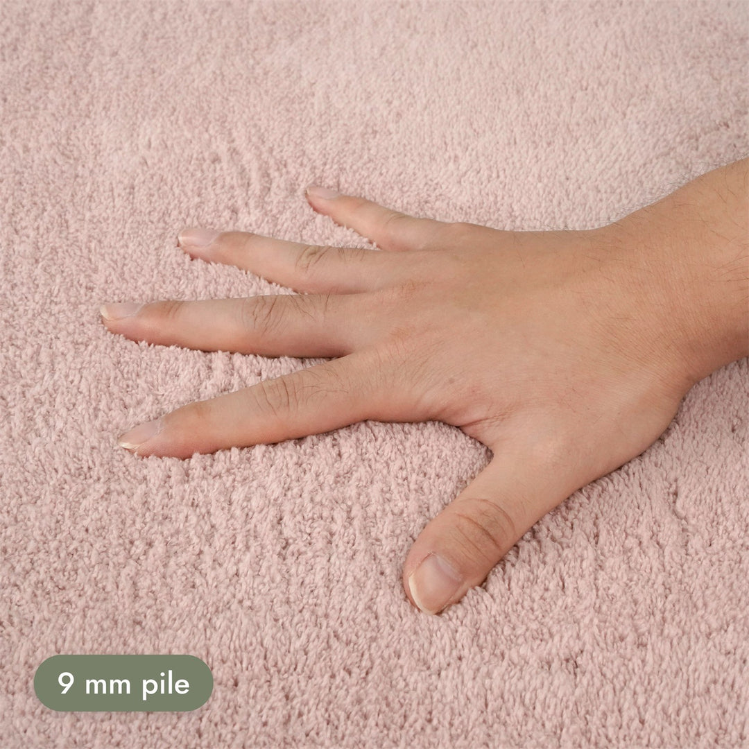 Washmellow pink washable rug, close-up of the soft 9mm pile under a hand | The Rugs