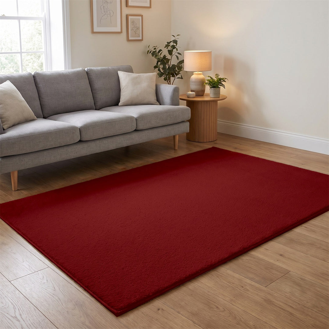 Washmellow red washable rug in a living room with a grey sofa and oak floor | The Rugs