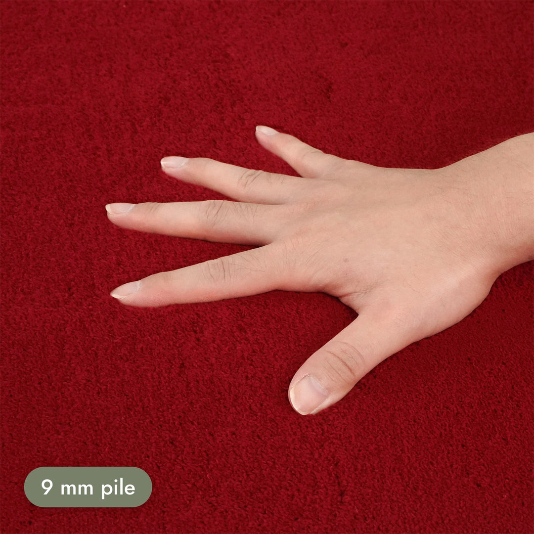 Washmellow red washable rug, close-up of the soft 9mm pile under a hand | The Rugs