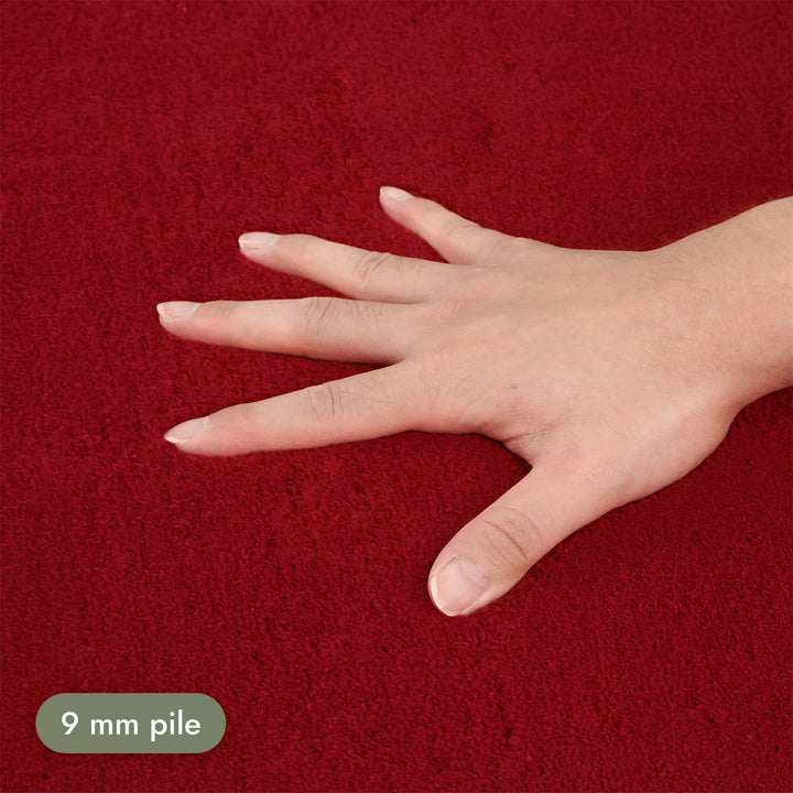 Washmellow red washable rug, close-up of the soft 9mm pile under a hand | The Rugs