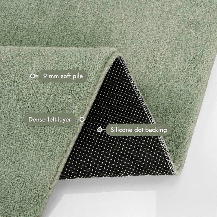 Washmellow sage green washable rug, folded corner showing the pile, felt layer and backing | The Rugs