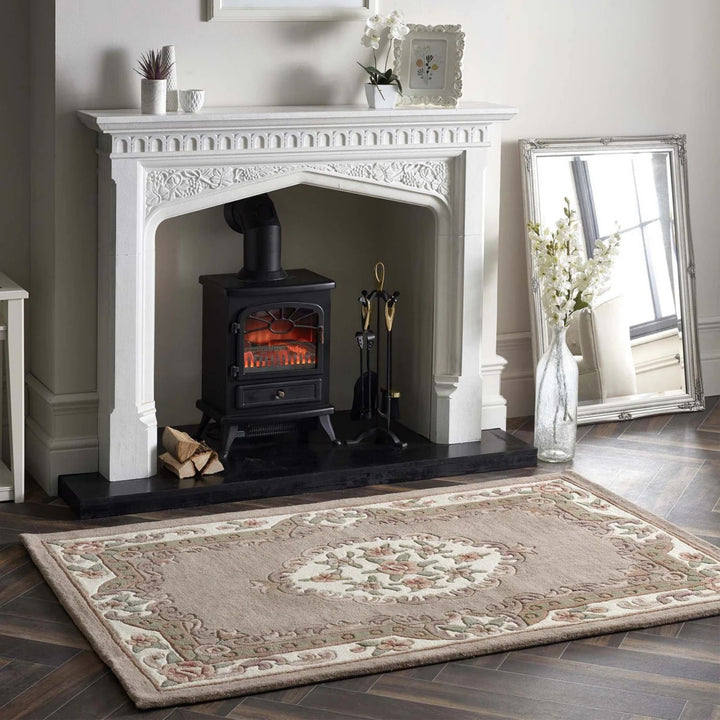 White fireplace with black stove, decorative rug, and mirror in a room.