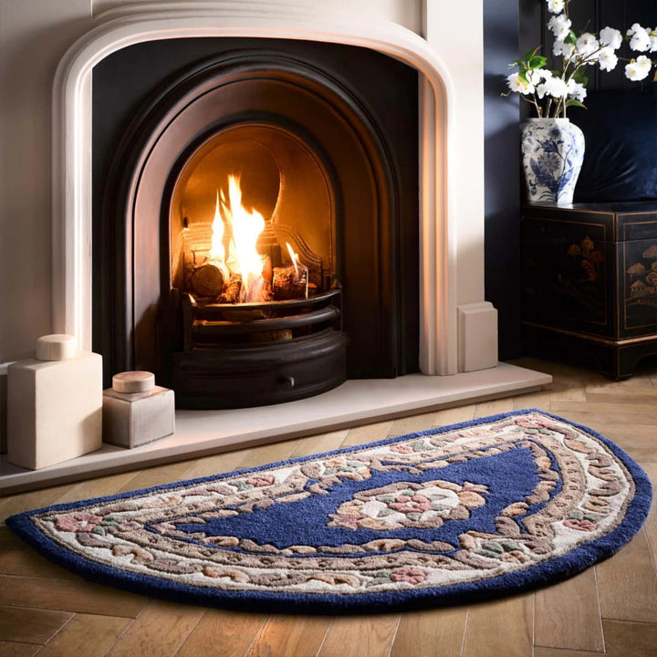 Decorative rug in front of a lit fireplace with a vase of flowers on a side table.